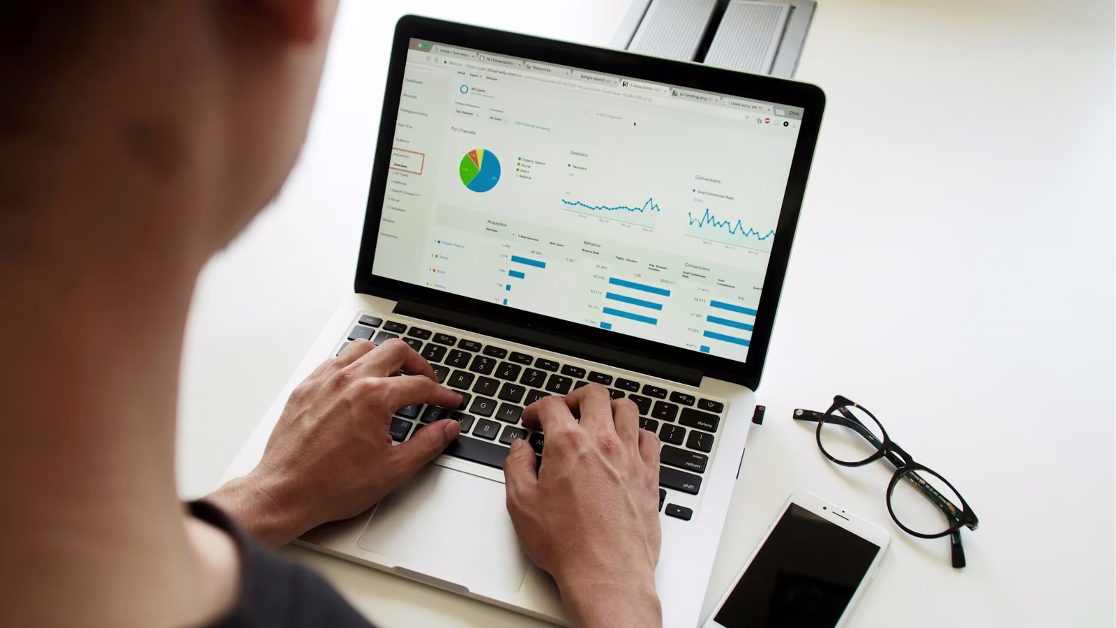 Persona revisando gráficas de analítica web en una laptop