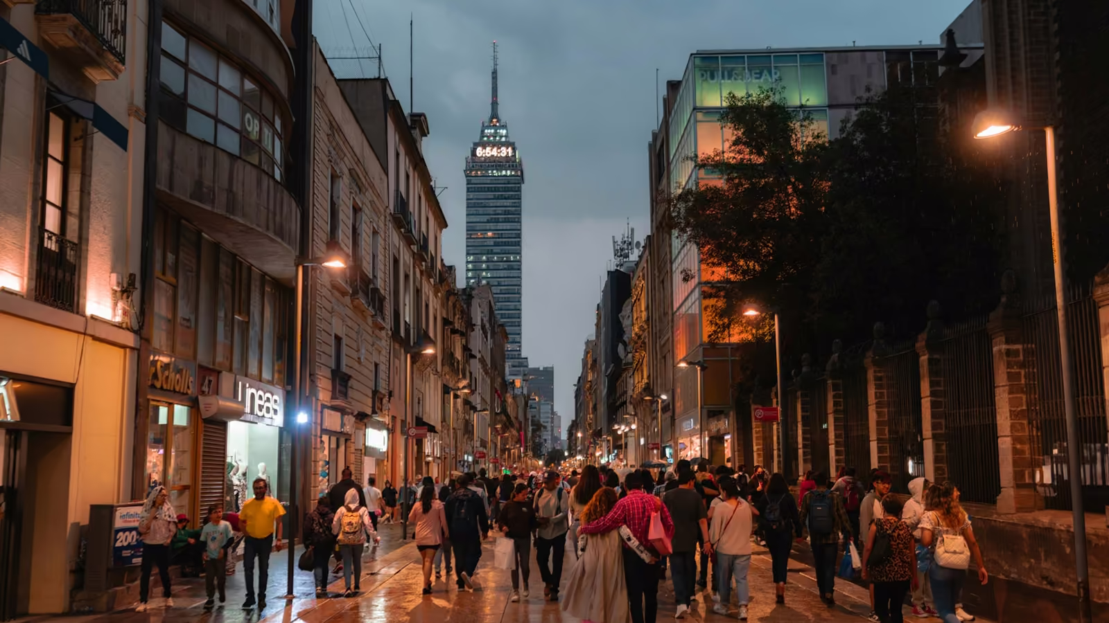 Calle peatonal con comercios en el centro de la Ciudad de México al anochecer