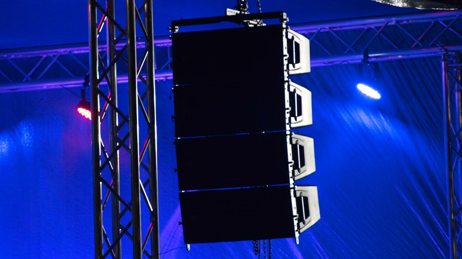Line array de bocinas suspendido en una estructura de escenario