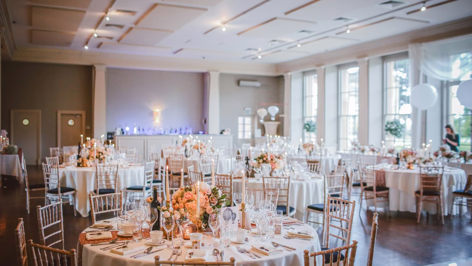Salón de eventos con mesas redondas montadas para un banquete