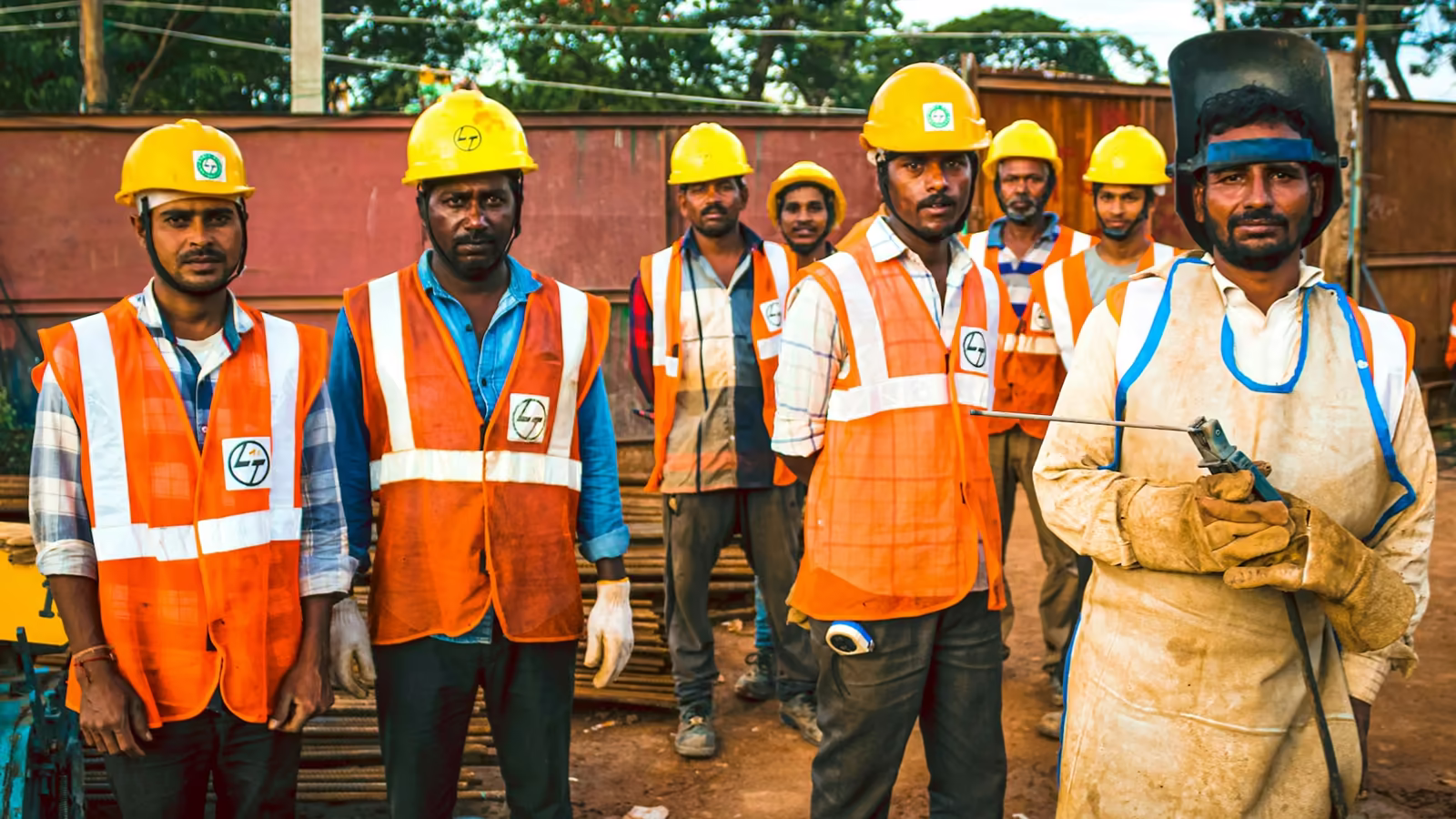 Equipo de trabajadores con casco y chaleco de seguridad en una planta industrial